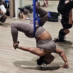 Woman in upside down aerial hip opener