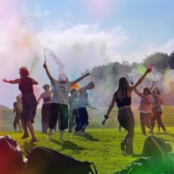 Festival goers celebrating outdoors with colourful powder.