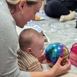 A new mum laughs and chats while she plays with her baby at The Nest