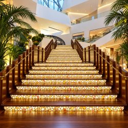 Interior of The Shops at Crystals featuring sculptural architecture, luxury storefronts, and colorful flower displays.