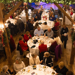 People eating at tables in a Barn