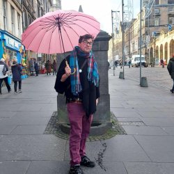 A picture of the tour guide with his pink umbrella, showing the start point for his LGBTQ tour