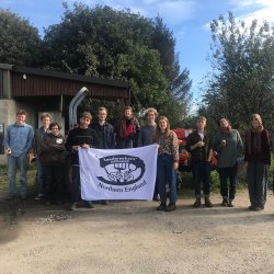 a group of FLAME members holding a landworkers alliance poster