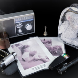 A table of ghost-hunting tools around a laminated picture of young Molly Ward