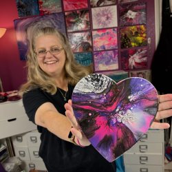 Erika holding one of her paint pour creations
