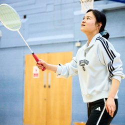 Person playing badminton in a sports hall