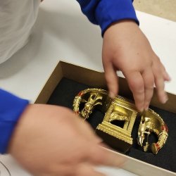 A school child handling a museum collection item