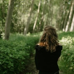 https://unsplash.com/photos/a-woman-walks-through-a-lush-green-forest-OOBVdQgRAl4