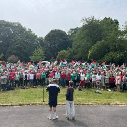A group of several hundred singers with Palestine flags at the Big Sing in Meersbrook park in the summer