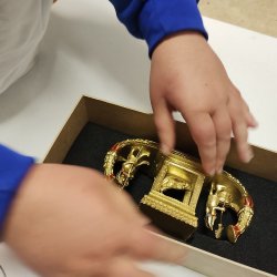 A school child handling a museum collection item