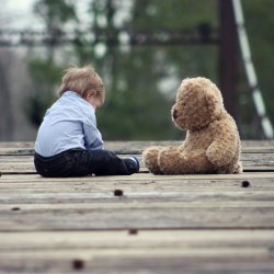 Small child facing a teddy bear
