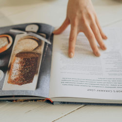 recipe book being held open and browsed by hand
