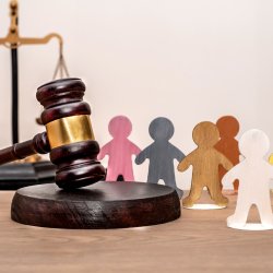 A gavel with colourful wooden figures beside it.