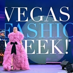 Model on the Vegas Fashion Week® runway wearing a dramatic pink feathered design previously worn by Lady Gaga, accented with a black bow.