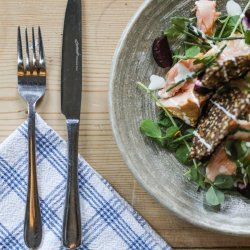 Dinner table set with a Scandi inspired meal of crispbreads and salmon with mixed leaves