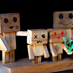 A wooden block family of four with emotions painted on their faces