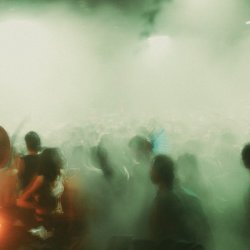 blurry dancefloor photo with people and smoke