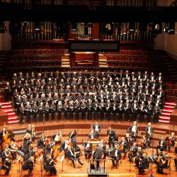 An orchestra setting up on stage