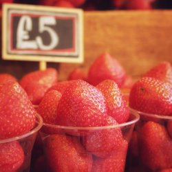 a close up of some strawberries in cups on a market stall - £5 a cup apparently!