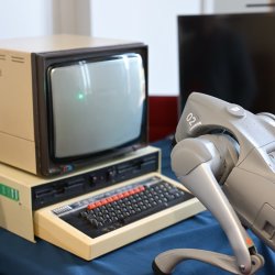 robot leaning over 1960s computer