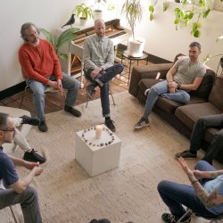 A group of men sitting in a circle talking