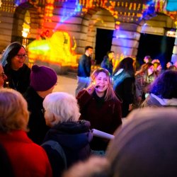 A group of people on a walking tour of nottingham market square listening to their host