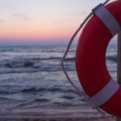 A lifebouy with sunset over the sea in background