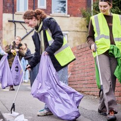 A photo of students picking litter on a street
