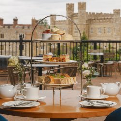Scones, strawberry jam and cream on the top of an afternoon tea stand.