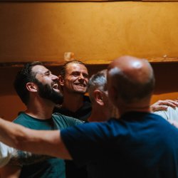 Een groep mannen die lachen en met elkaar in verbinding staan