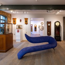 Image shows the main space at The Clockworks, with nineteenth-century clocks displayed around the walls