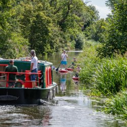 Chelmer and Blackwater Canal - July 2020 Paul Freeman credit  picture of the Blackwater Dawn canal boat with guests and paddle boarders along the navigation