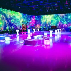 The Portal at AREA15 with colorful immersive wall projections and illuminated lounge seating.