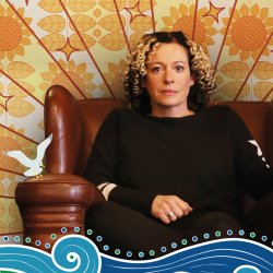 Kate Rusby seated with 70s wallpaper