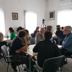 Group of people sat around tables in discussion