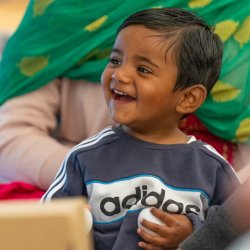 A young baby and their carer playing with a musical instrument