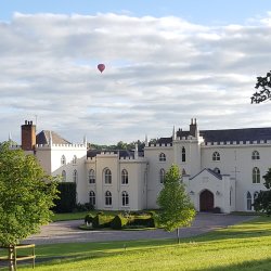 An image showing the front of the Abbey with a hot air balloon in the sky above.