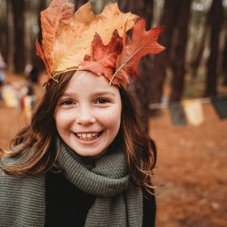 Girl in autumn leaves crown Photo by Jessie Maxwell on Unsplash