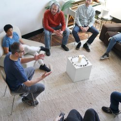 A group of men sitting in a circle talking