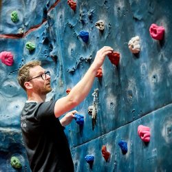 Participants bouldering on the climbing wall as part of an Active Campus session