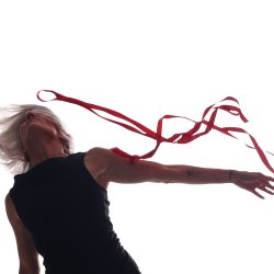 Dancer dressed in black, reaching to left