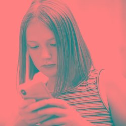 A photograph of a young person scrolling on their phone.