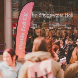 A branded Fiction Fest UK flag in front of the Bridgewater Hall