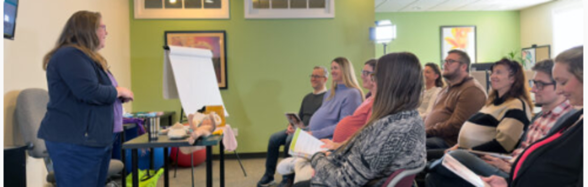 Debbie Young in front of a room of students teaching a Childbirth Education Class