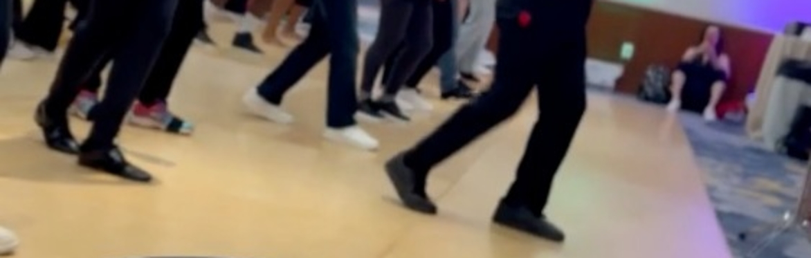 Dancers practicing salsa with a conga drum in the foreground