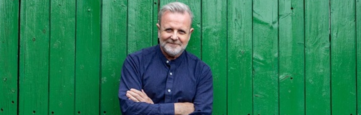 Michael Londra standing in front of large green door