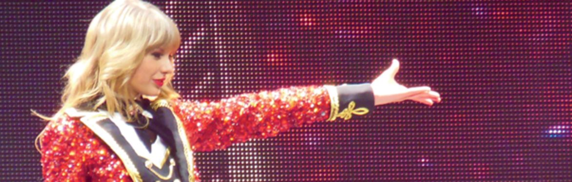 Taylor Swift onstage playing a guitar
