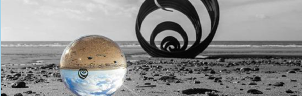 Sculpture and glass ball on a beach
