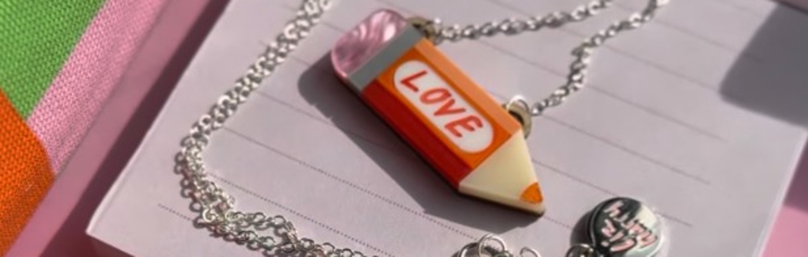 An acrylic necklace with the word Love hand written across the middle
