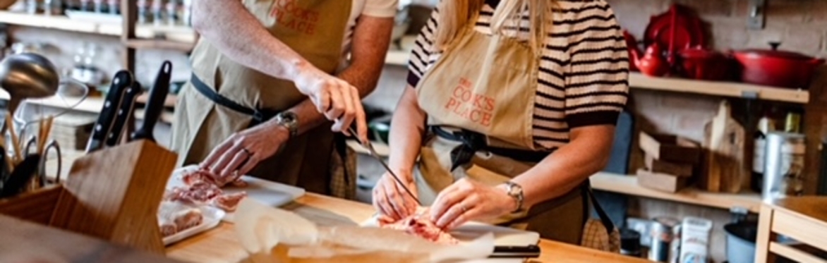 Two people preparing food in a cookery school